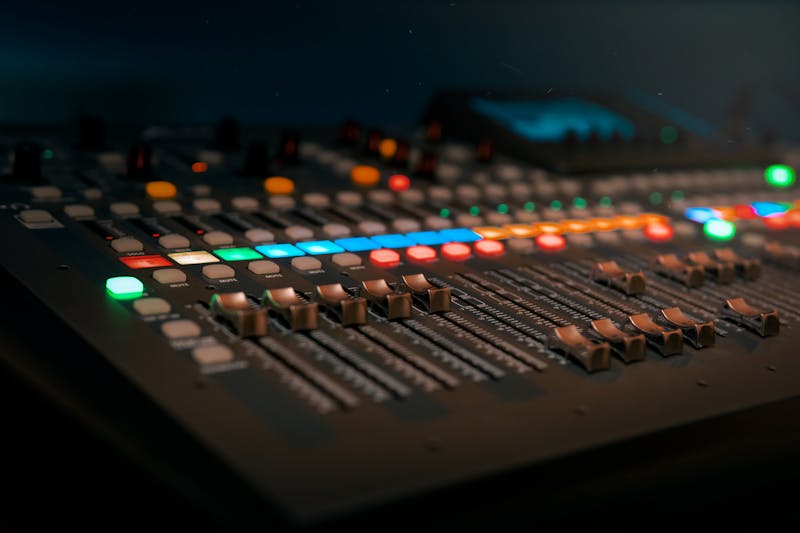 Console de mixage professionnelle avec faders et boutons lumineux